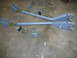 1992 Ford Mustang - A set of gray control arms and assorted hardware are displayed on a concrete surface.