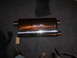 1991 Ford Bronco - A shiny SLP exhaust muffler is shown on a dark carpeted surface.