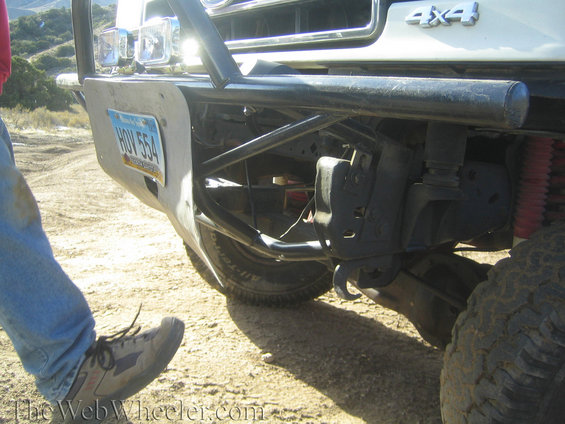 White SUV front bumper with license plate HOV 554, off-road lights, and brush guard
