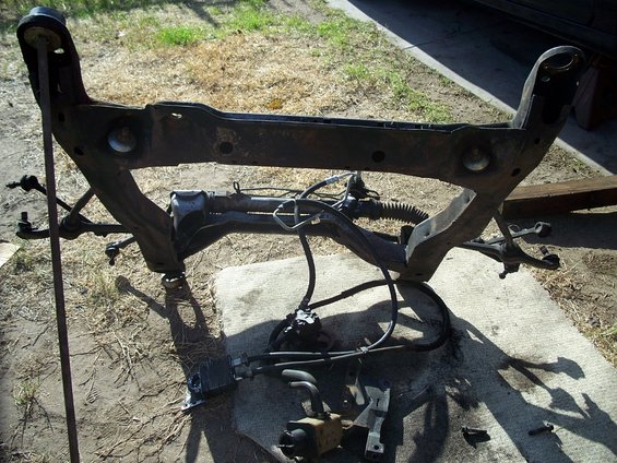 Automotive subframe assembly with steering rack and power steering pump removed from a vehicle