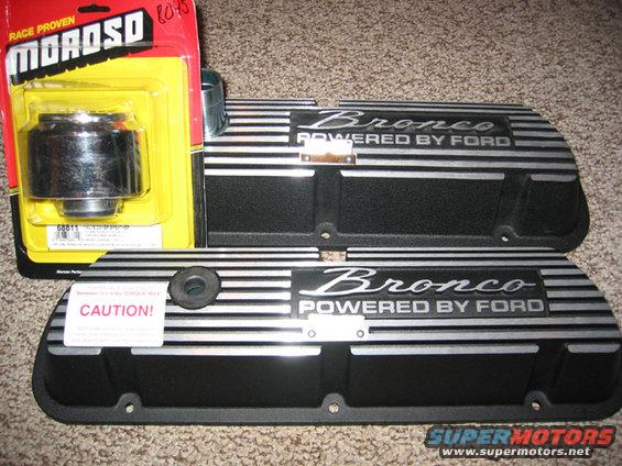 Pair of black Ford Bronco valve covers with silver stripes and 'Bronco POWERED BY FORD' text, next to a yellow Moroso oil filter package