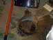 1989 Ford Bronco - Differential assembly removed from a vehicle, resting on the floor next to tools and shop supplies.