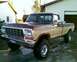 1979 Ford F-150 - A two-tone brown and tan 1979 Ford F-150 pickup truck is parked in front of a garage.