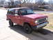 1984 Ford Bronco II - This red Ford Bronco II is parked on a concrete driveway in front of suburban houses.