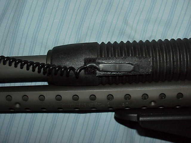 Close-up of a gun's forend with a coiled wire attached