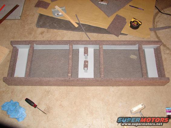 custom speaker enclosure with multiple compartments, tools and carpet scraps around it