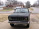 1984 Ford Bronco II - Front view of a matte black 1983 Ford Bronco II parked in a driveway, showing its grille and chrome bumper.