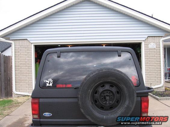 1984 Ford Bronco II rear view with spare tire mounted on the back door, showing a 'System of a Down' sticker
