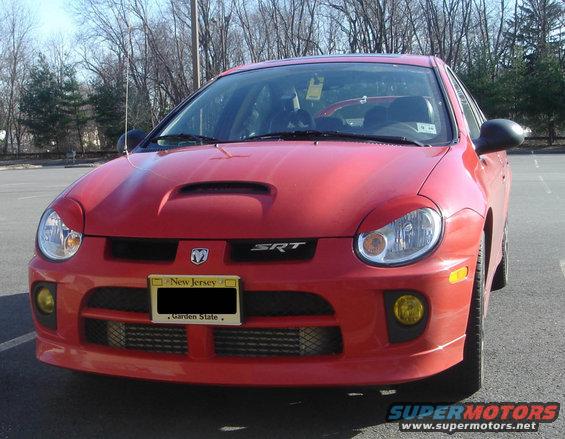 Red 2005 Dodge SRT-4 front view, showing scoop on hood, yellow fog lights, and New Jersey license plate