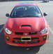 2005 Dodge SRT-4 - Front view of a red 2005 Dodge SRT-4 parked in a lot, displaying its distinctive hood scoop and SRT badging.