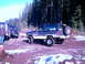 1987 Ford Bronco II - A group of off-road vehicles are parked in a snowy, wooded area, with one Bronco II prominently featured.