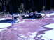 1987 Ford Bronco II - Three off-road vehicles, including a 1987 Ford Bronco II, are parked in a snowy forest clearing.
