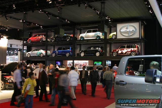 Scion display with cars on shelves, including a red tC and a blue xB