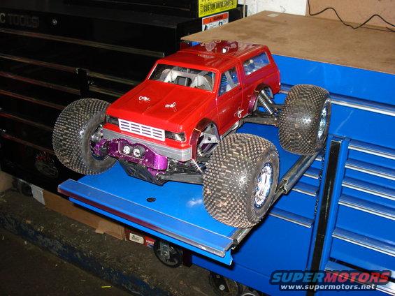 Red remote control truck with large tires and purple suspension components
