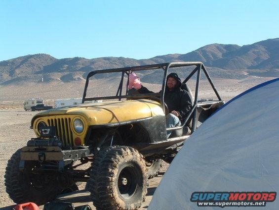 Yellow 1994 Jeep YJ with roll cage and large tires in desert