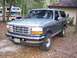 1996 Ford Bronco - This 1996 Ford Bronco is parked in a wooded area next to a house, with an RV visible in the background.