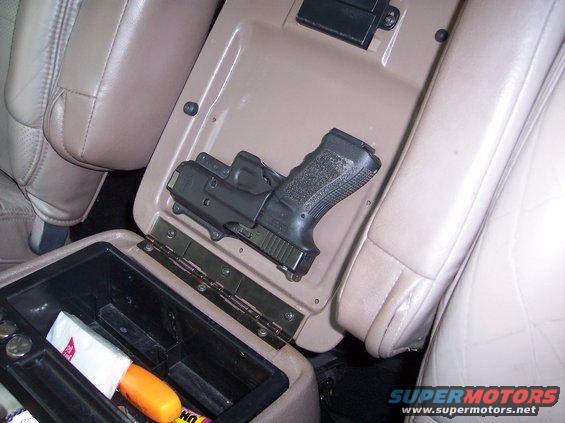 The Road Rage Tactical Response Device. I took a little-used holster and attached it with screws to the inside of the center console lid...yes, I have a permit for it