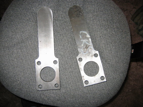Two metal brackets with circular cutouts and four bolt holes, one marked with 'CR' and '18'