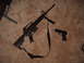 1988 Ford Bronco - An assault rifle and a handgun are placed on a carpeted surface next to a table leg.