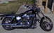 2004 Ford Crown Victoria - A black Harley-Davidson motorcycle is parked on a paved surface with a grassy area in the background.