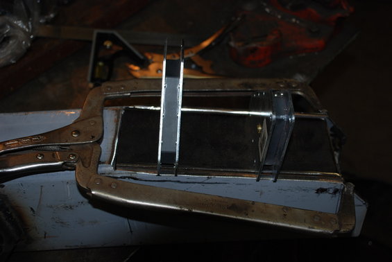 Metal panel being clamped and measured for repair
