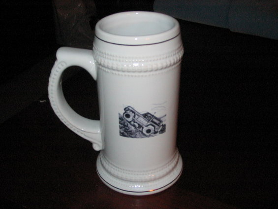 White ceramic stein with a black graphic of an off-road vehicle on a hill