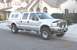 2004 Ford F-250 - This silver 2004 Ford F-250 pickup truck is equipped with a camper shell and roof rack.