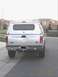 2004 Ford F-250 - Rear view of a silver 2004 Ford F-250 pickup truck equipped with a camper shell and aftermarket wheels.