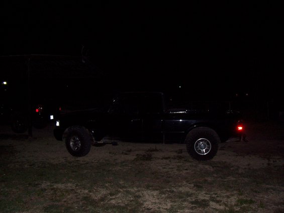 black pickup truck parked on dirt at night