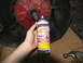 1978 Ford Bronco - A can of PB Blaster penetrating oil is held near a vehicle's transmission housing, suggesting maintenance or repair work.