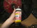 1978 Ford Bronco - A can of PB Blaster penetrating catalyst is held near a vehicle transmission part, suggesting maintenance or repair.