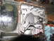 1978 Ford Bronco - The transmission pan has been removed, revealing the internal workings and some residual fluid.