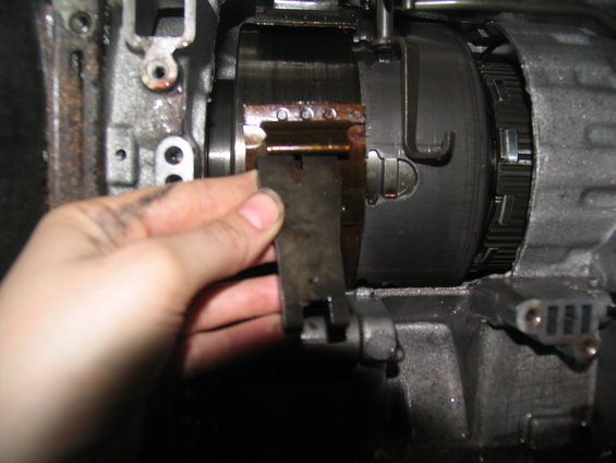 Hand holding metal clip inside transmission assembly