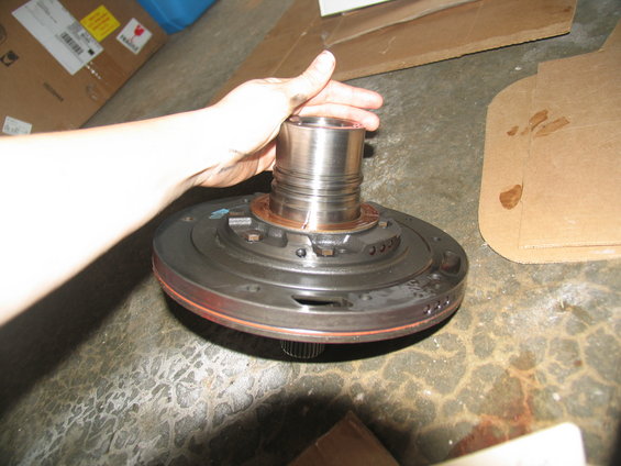 Hand holding a metal transmission pump component with splines