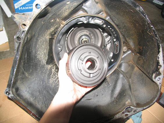 Transmission torque converter clutch held in front of transmission housing