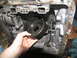 1978 Ford Bronco - A person is holding a disassembled transmission gear within the transmission casing.
