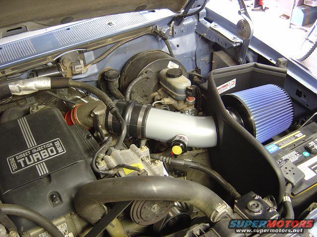engine bay showing a turbo diesel engine with a K&N air intake system and blue filter