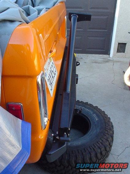 1977 Ford Bronco rear quarter panel, orange paint, California license plate 3AYK523, and spare tire mounted on rear bumper