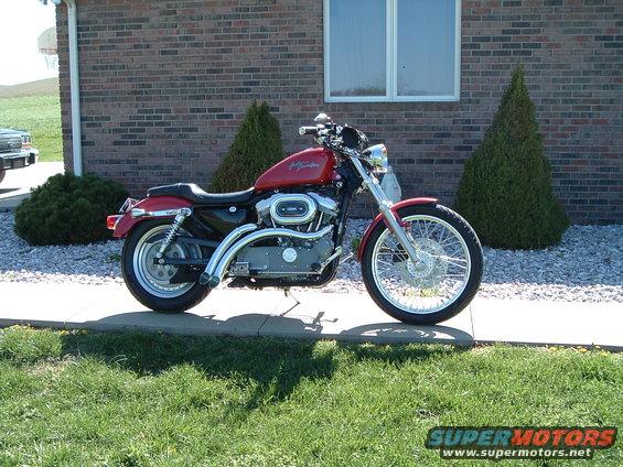 Red 2002 Harley-Davidson Sportster Custom motorcycle parked on a sidewalk