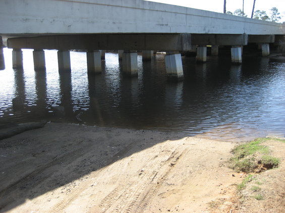 Tire tracks on sandy ramp under bridge