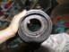 1978 Ford Bronco - A hand holds a transmission clutch drum, revealing internal components and dark fluid.
