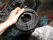1978 Ford Bronco - Transmission part being held, with oil dripping onto rags and the floor.