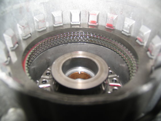 Close-up of a transmission clutch pack with red fluid visible in small plastic bags