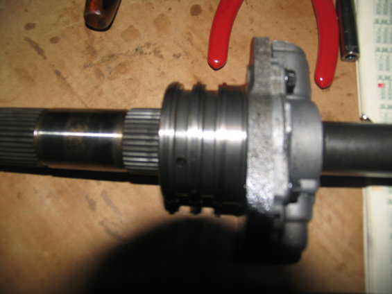 Transmission shaft with splines and a metal housing with grooved rings