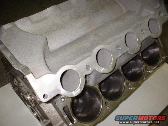 Close-up of an engine block with cylinders and an intake manifold on top