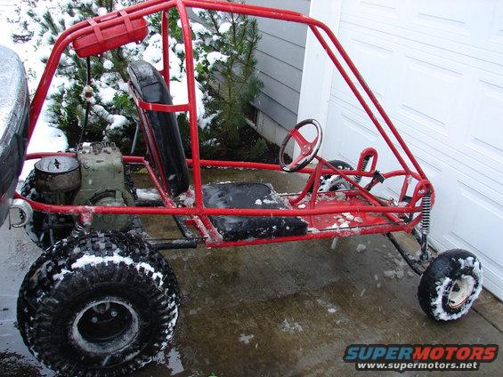 Red buggy with roll cage and off-road tires in snow