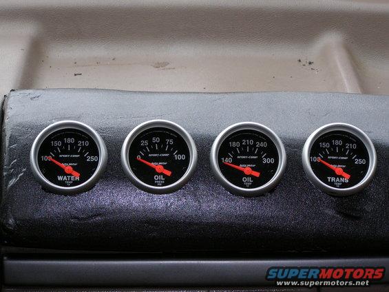 Four gauges mounted on a dashboard: water temp, oil pressure, oil temp, and trans temp