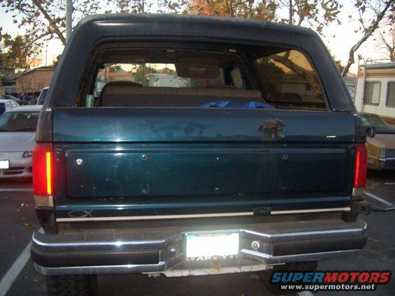 Rear view of a dark green SUV, possibly a Ford Bronco, with a license plate visible