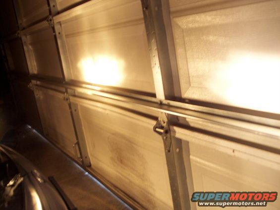 Overhead garage door with lights reflecting off the panels
