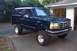 1994 Ford Bronco - This lifted Ford Bronco is parked in front of a garage.
